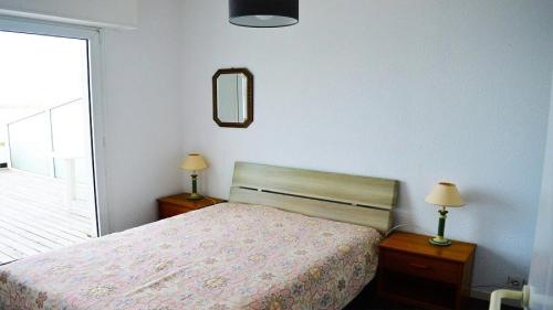- une chambre avec un lit, deux lampes et un miroir dans l'établissement Résidence Les Sept Iles - Vacances vue mer à 180°et les pieds dans l'eau ! MAE-3504, à Trégastel