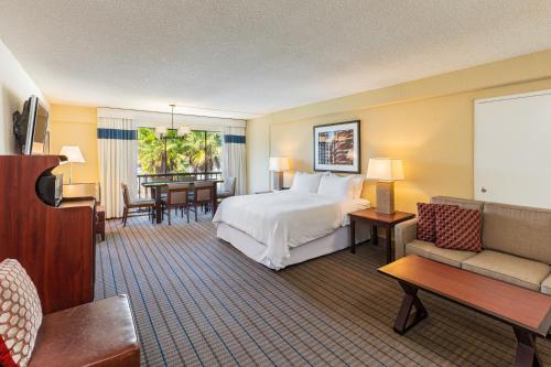 サンラファエルにあるFour Points by Sheraton San Rafael Marin Countyのベッドとリビングルームが備わるホテルルームです。