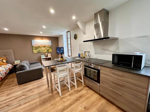 une cuisine et un salon avec une table et un canapé dans l'établissement Les appartements du Palais, à Carcassonne