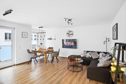 uma sala de estar com um sofá e uma mesa em TomsFlat BRAUNSCHWEIG - 3 ROOMS, KITCHEN, WORKSPACE, HIGHSPEED WIFI, WASHER & DRYER, BALCONY em Braunschweig