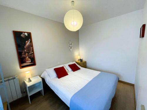 - une chambre avec un lit blanc et 2 oreillers rouges dans l'établissement Résidence Le Casino - Appartement vue sur les sept îles à Perros Guirec MAE-3534, à Perros-Guirec