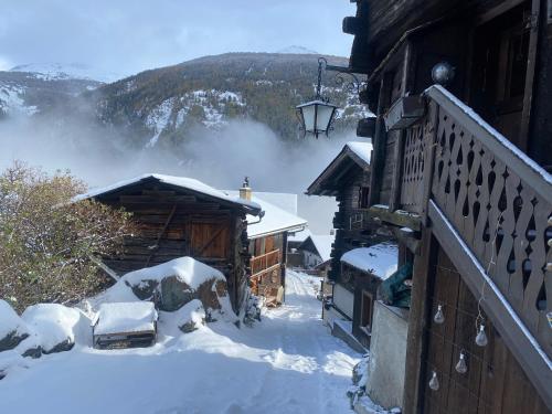 una baita di tronchi nella neve con camino di Un nid au paradis - Chalet traditionnel avec beaucoup de cachet a Mayoux