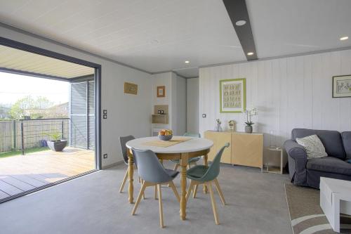 un salon avec une table, des chaises et un canapé dans l'établissement Le Chalet Cetri - Welkeys, à Saubrigues