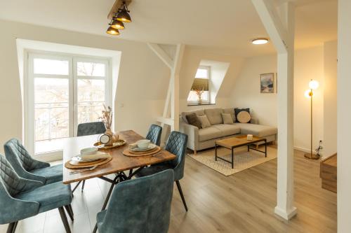 een eetkamer en een woonkamer met een tafel en stoelen bij soulscape Apartments Zwickau kompakter LOFT-Wohnraum mit Lift direkt in die Wohnung, modern, zentrumsnah, gratis WIFI in Zwickau