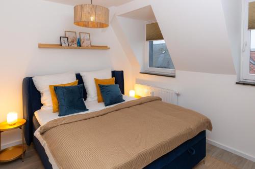 een slaapkamer met een bed met blauwe en oranje kussens bij soulscape Apartments Zwickau kompakter LOFT-Wohnraum mit Lift direkt in die Wohnung, modern, zentrumsnah, gratis WIFI in Zwickau