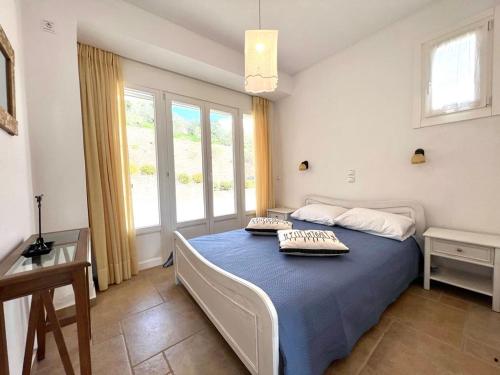 a bedroom with a bed with two pillows on it at Grand Blue Terrace - Island house by Hostandros in Batsi