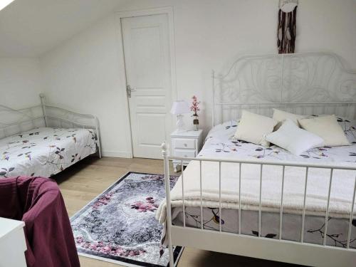 - une chambre blanche avec 2 lits et un tapis dans l'établissement Résidence Ker Sanmamaleo - Villa Ker Sanmamaleo vacances près de la plage MAE-3604, à Pleumeur-Bodou