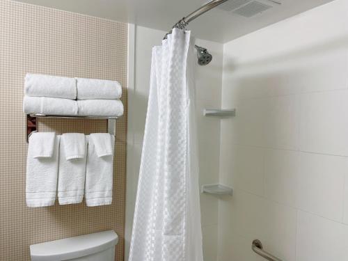 a bathroom with a white shower curtain and towels at Four Points by Sheraton San Rafael Marin County in San Rafael