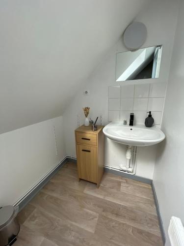 a white bathroom with a sink and a mirror at Le Touquet in Le Touquet-Paris-Plage