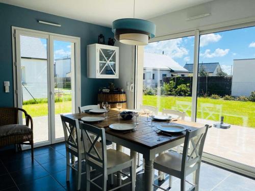 une salle à manger avec une table et des chaises en bois dans l'établissement Résidence L38-pleumeur Bodou - Maison avec jardin et parking, plage à 100 mètres MAE-3644, à Pleumeur-Bodou