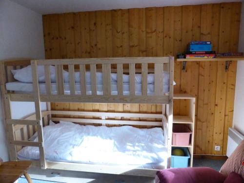 Ce lit superposé se trouve dans un dortoir doté d'un mur en bois. dans l'établissement Résidence Les Trolles - Trolles 5A MAE-7374, aux Contamines-Montjoie