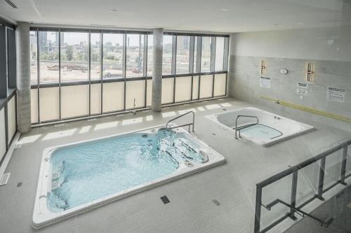 a large jacuzzi tub in a large room at Modern 1BR King Bed Condo - Private Balcony in Kitchener
