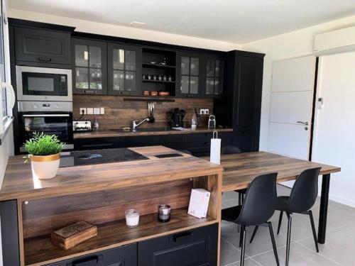 une cuisine avec des armoires noires et un comptoir en bois dans l'établissement Résidence L53-trebeurden - Da Viken jolie maison jardin clos et parking privé MAE-3694, à Trébeurden