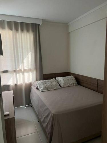 een slaapkamer met een bed met twee kussens erop bij Apartamento Edificio Sunset 1404 in Vila Velha