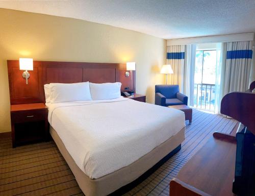 a hotel room with a large bed and a chair at Four Points by Sheraton San Rafael Marin County in San Rafael