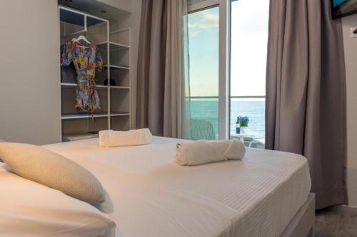 a bedroom with a large white bed with a window at Ocean Dreams in Palaiochóra