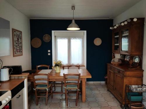 Il comprend une cuisine avec une table et des chaises en bois. dans l'établissement Résidence I22-ile Grande - Les Mouettes maison vue mer jardin et parking privé, plage à pied MAE-3734, à Pleumeur-Bodou