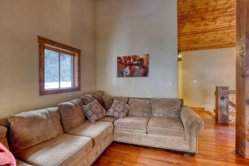 a brown couch in a living room with a window at Silver King Lodge in Deadwood