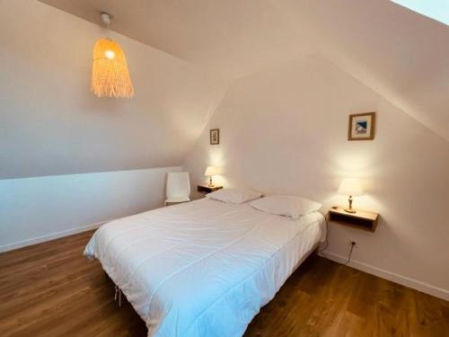 um quarto com uma cama branca e duas mesas de cabeceira em Résidence L-tregastel - Maisons & Villas 374 em Trégastel