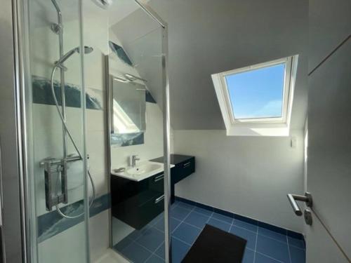 een badkamer met een douche, een wastafel en een raam bij Résidence L-tregastel - Maisons & Villas 374 in Trégastel