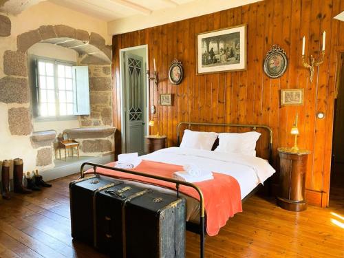 - une chambre avec un lit et une valise dans l'établissement Résidence D02-tregastel - Vacances près de la mer dans une maison médiévale MAE-4284, à Trégastel