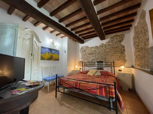 a bedroom with a bed and a tv in a room at La Casa di Gelsomino in Massa Martana