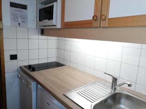 um balcão de cozinha com um lavatório e um micro-ondas em CACHETTE G - Appartement CACHETTE 24 pour 4 Personnes 40 em Valmorel