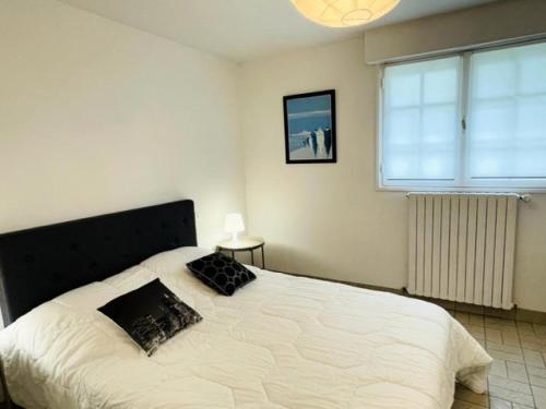 une chambre avec un grand lit blanc avec deux oreillers dans l'établissement Résidence C26-tregastel - Appartement dans villa à 100 mètres de la plage MAE-3034, à Trégastel