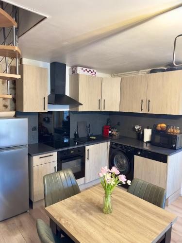 une cuisine avec une table avec un vase de fleurs dessus dans l'établissement Charmante maison mitoyenne, à Melun