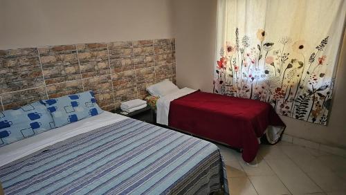 a hotel room with two beds and a window at SOCRA Centro in Asunción