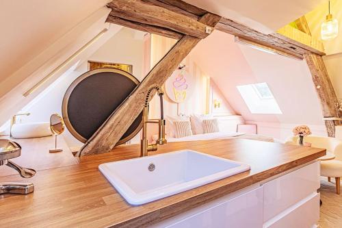 une salle de bain avec un lavabo au milieu d'une pièce dans l'établissement Le Milkshake - Hypercentre, Cinéma, King size, à Troyes