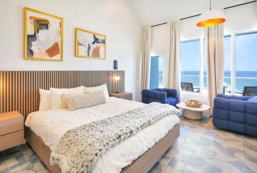 a bedroom with a large bed and blue chairs at Cobalt Coast Resort in West Bay