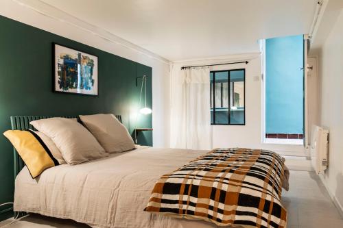 ein Schlafzimmer mit einem großen Bett und einer grünen Wand in der Unterkunft Le Jardin d'Hiver Saint Victor in Marseille