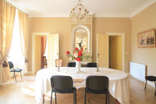 een eetkamer met een tafel met een vaas met bloemen bij Chateau Sénailhac in Tresses