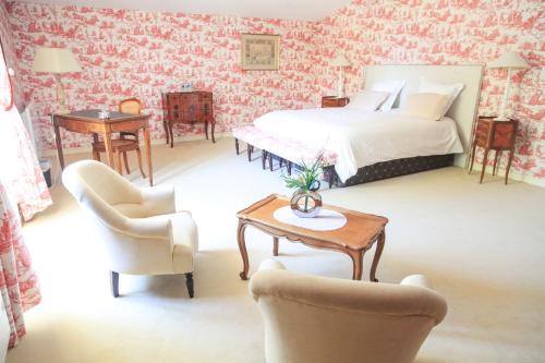 a bedroom with a bed and a table and chairs at Château senailhac in Tresses