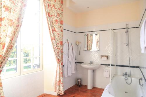 une salle de bain avec une baignoire et un lavabo dans l'établissement Chateau Sénailhac, à Tresses