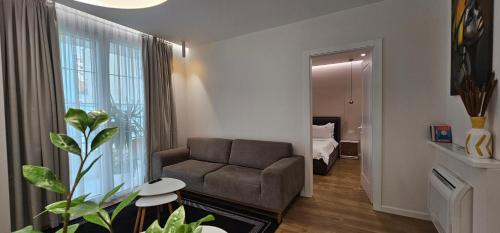 ein Wohnzimmer mit Sofa und ein Schlafzimmer in der Unterkunft TAM Serviced Apartment City Center No3 in Tirana
