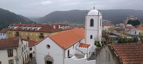 Blick auf eine Stadt mit einem Uhrturm in der Unterkunft Mondalva Guesthouse in São Pedro de Alva