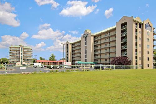 a large building with a grass field in front of it at River Place Condos #401 2BD in Pigeon Forge