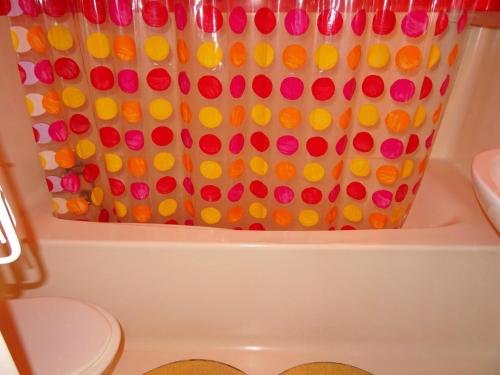 La salle de bains est pourvue d'un rideau de douche avec des boutons colorés. dans l'établissement Résidence Pierra Menta - Appartement spacieux de 4 pièces pour 9 personnes en dernier étage, proche des pistes et des commerces dans le village du Charve MAE-1660, à Arc 1800