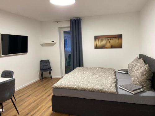 a bedroom with a bed and a flat screen tv at Bruchersee 4 oberbergisches Land in Marienheide