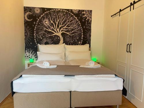a bedroom with a bed with a tree mural on the wall at TAMLiving Mureck-NEU-Voll Ausgesattet-Küche-Smart TV-WIFI-Parken Frei in Mureck