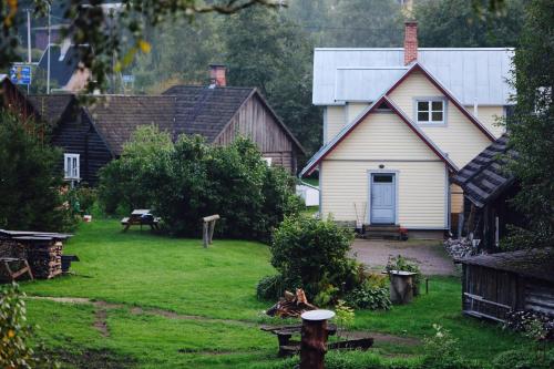 a white house with a porch and a yard at Rosma Mill Holiday House in Põlva