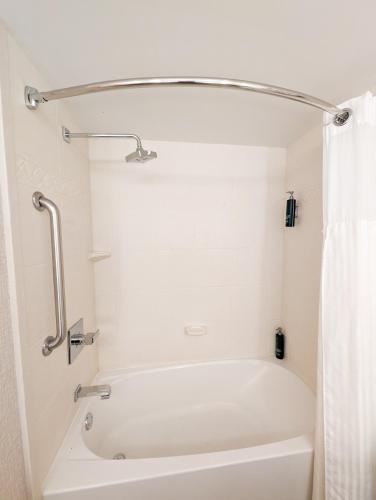 a white bath tub in a bathroom with a shower curtain at DoubleTree by Hilton Murfreesboro in Murfreesboro