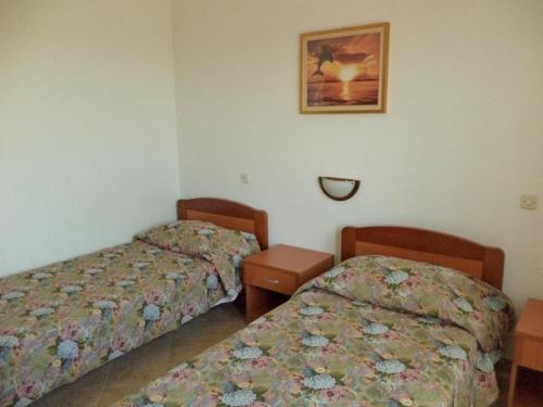 Zimmer mit 2 Betten und einem Bild an der Wand in der Unterkunft Ferienwohnung mit Balkon für fünf Personen in Pula