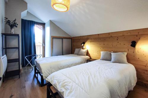 a bedroom with two beds and a large window at CHALET LUMI - Chalet CHALET MAGDALENA pour 6 Personnes 624 in Valmorel