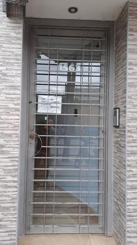 a door with a dog sitting behind a gate at ALOJAMIENTO NORTE 1 in Santiago del Estero