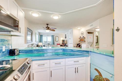 a large kitchen with blue counter tops at Carolina Beach Condo with Balcony and Ocean Access! in Carolina Beach