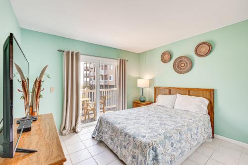 a bedroom with a bed and a tv in it at Carolina Beach Condo with Balcony and Ocean Access! in Carolina Beach