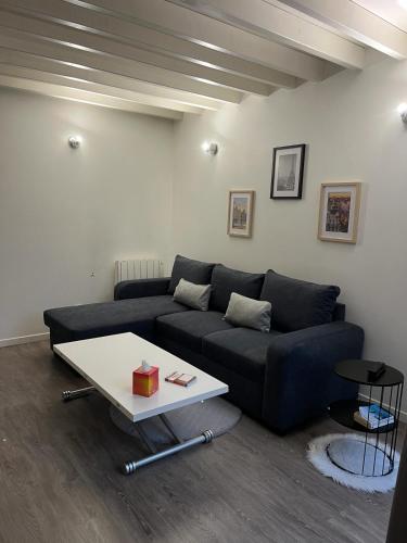 - un salon avec un canapé bleu et une table dans l'établissement Villa Camelia Rueil malmaison métropole grand Paris, à Rueil-Malmaison